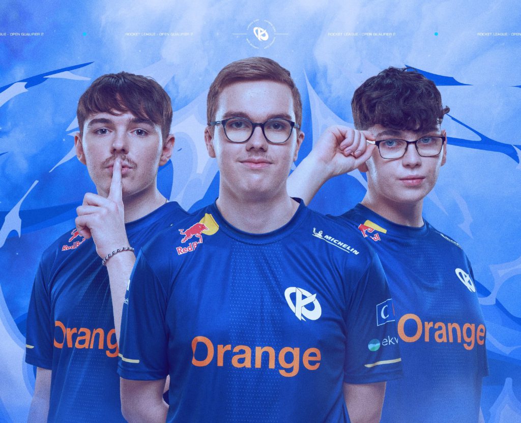 Trois joueurs de l'équipe esportive Karmine Corp posent en maillots bleus sponsorisés par Orange, Red Bull et Michelin, sur un fond bleu avec des motifs abstraits.