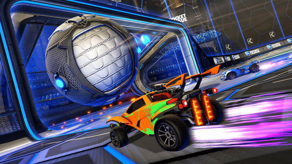 Une voiture orange de Rocket League s'apprête à frapper une grande balle métallique près du but, avec une traînée lumineuse violette derrière elle, dans un stade.